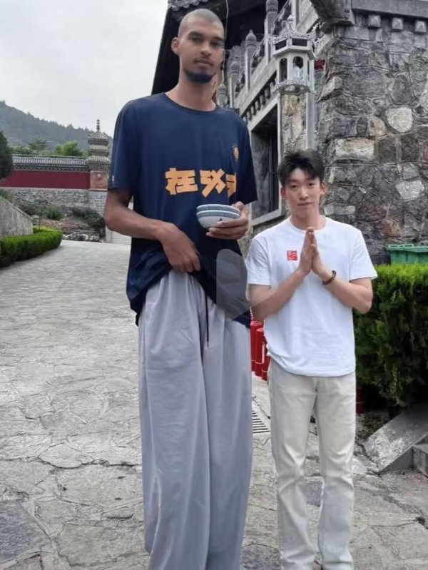 Wenban took a photo with fans at Shaolin Temple 📸 holding two bowls & in his hand wearing a 